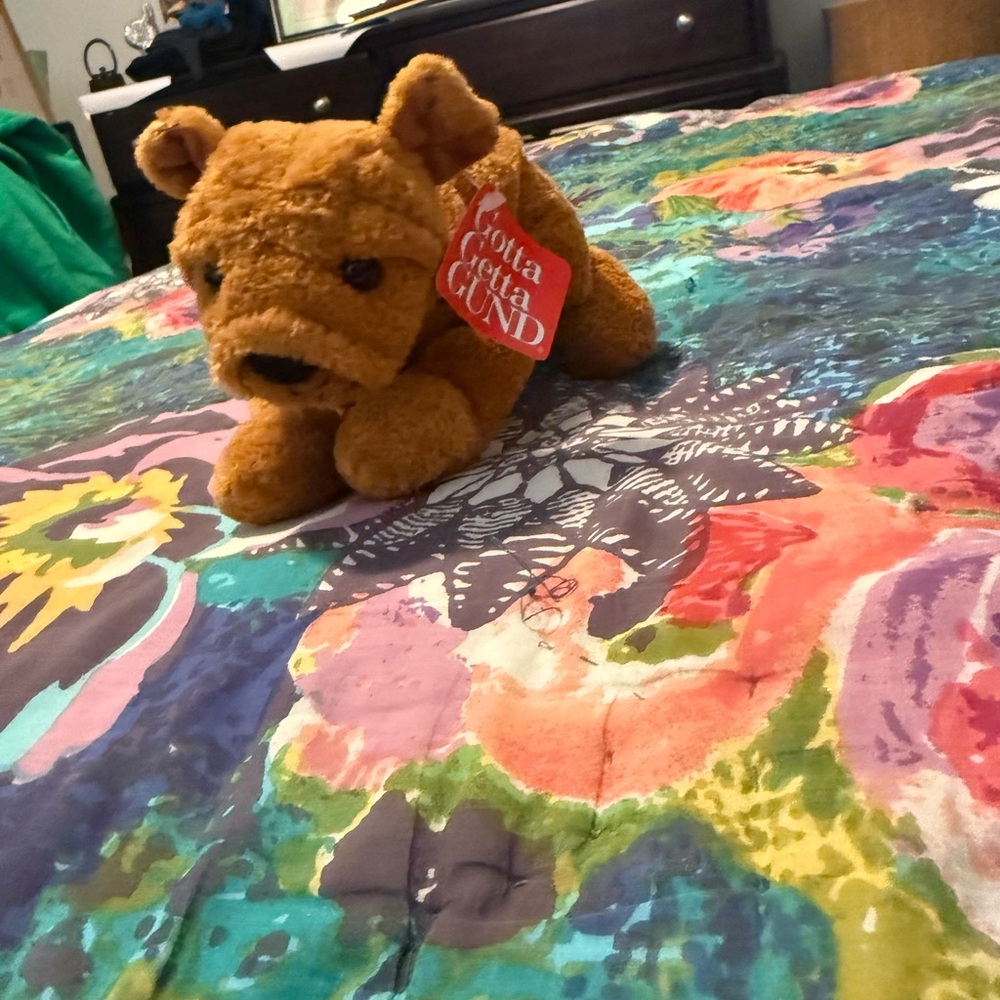 Gund Brown Plush Dog on Vibrant Floral Bedding